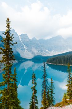Majestic panorama of Moraine Lake with turquoise waters and Canadian Rockies under a blue sky.