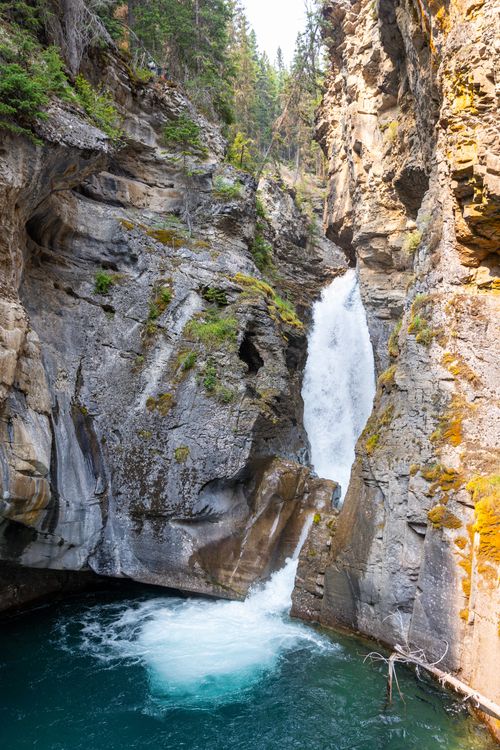 Free Beautiful waterfall cascading through rocky cliffs at Johnston Canyon, Banff National Park. Stock Photo