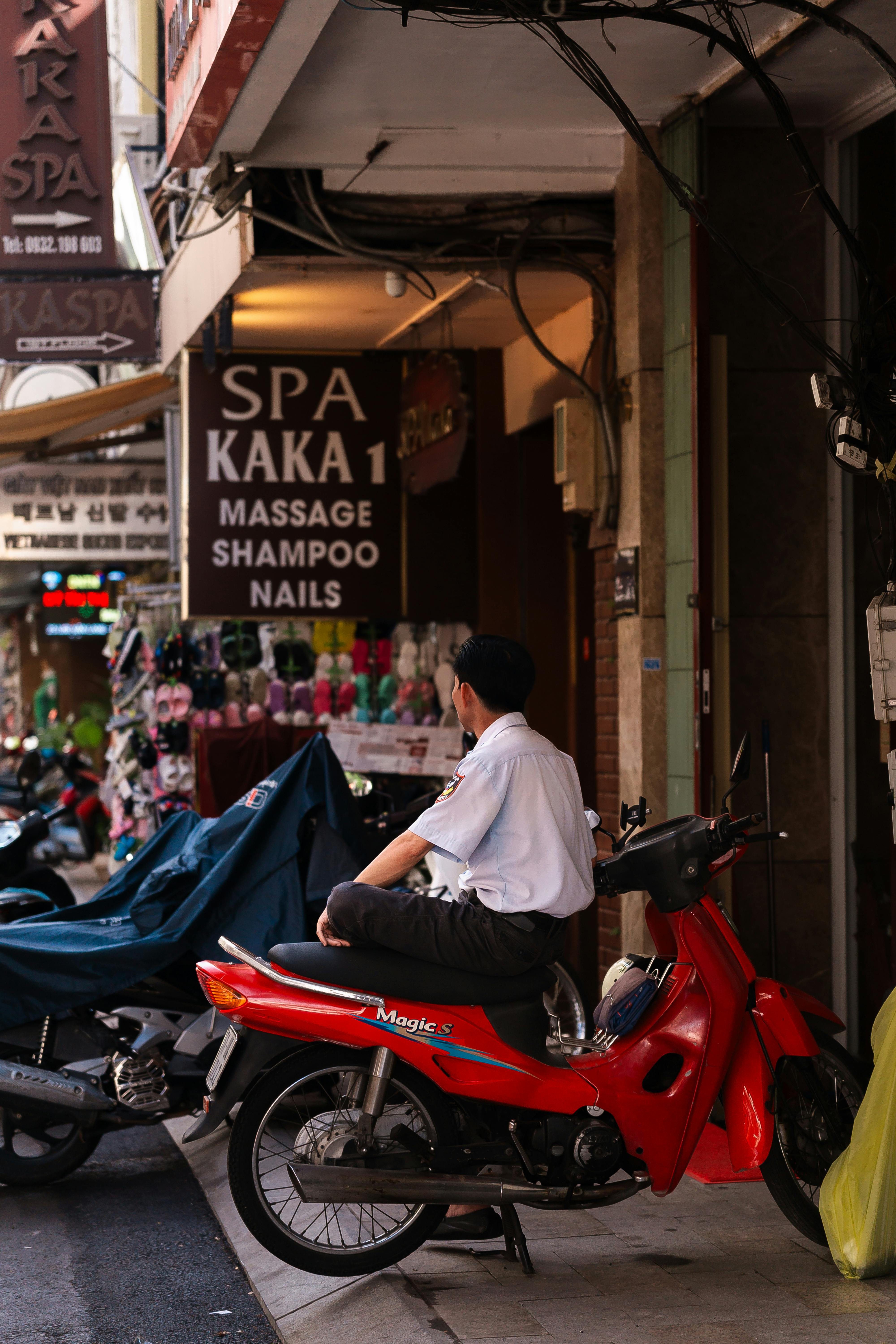 Man on scooter in vibrant urban Asian street
