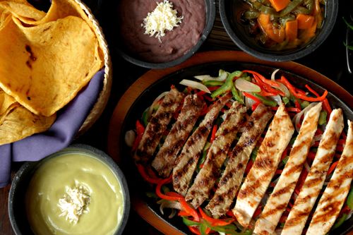 Free Vibrant array of Mexican fajitas with beans, avocado dip, and tortillas. Perfect for culinary inspiration. Stock Photo