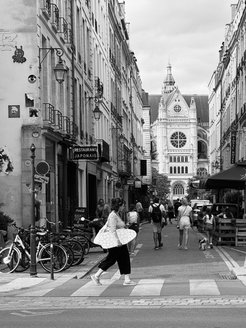 Charming Paris street scene with Saint-Eustache Church in the background, showcasing lively city life.