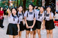Group of Schoolgirls Pointing and Smiling Outdoors