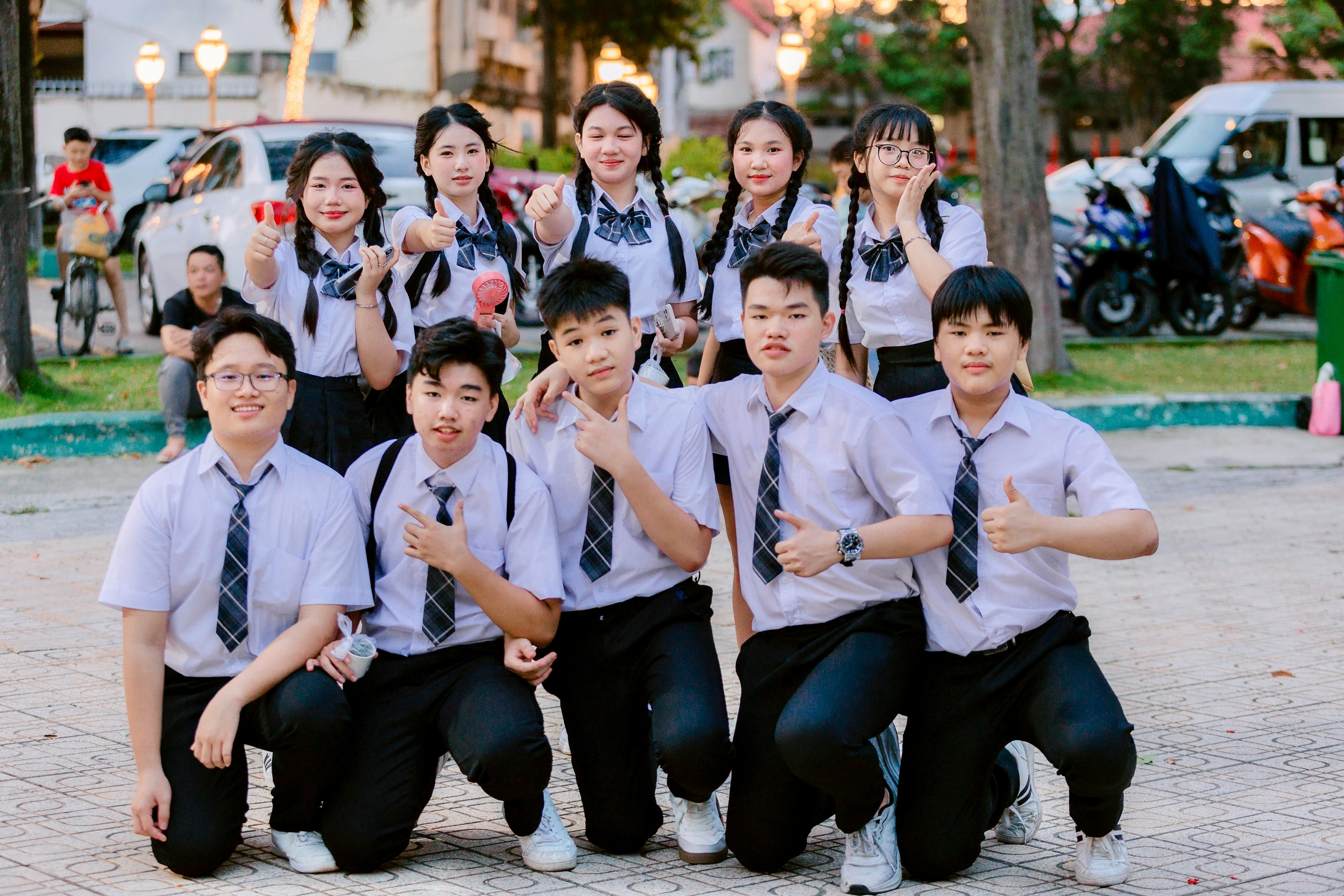 Group of students in uniform posing outdoors · Free Stock Photo