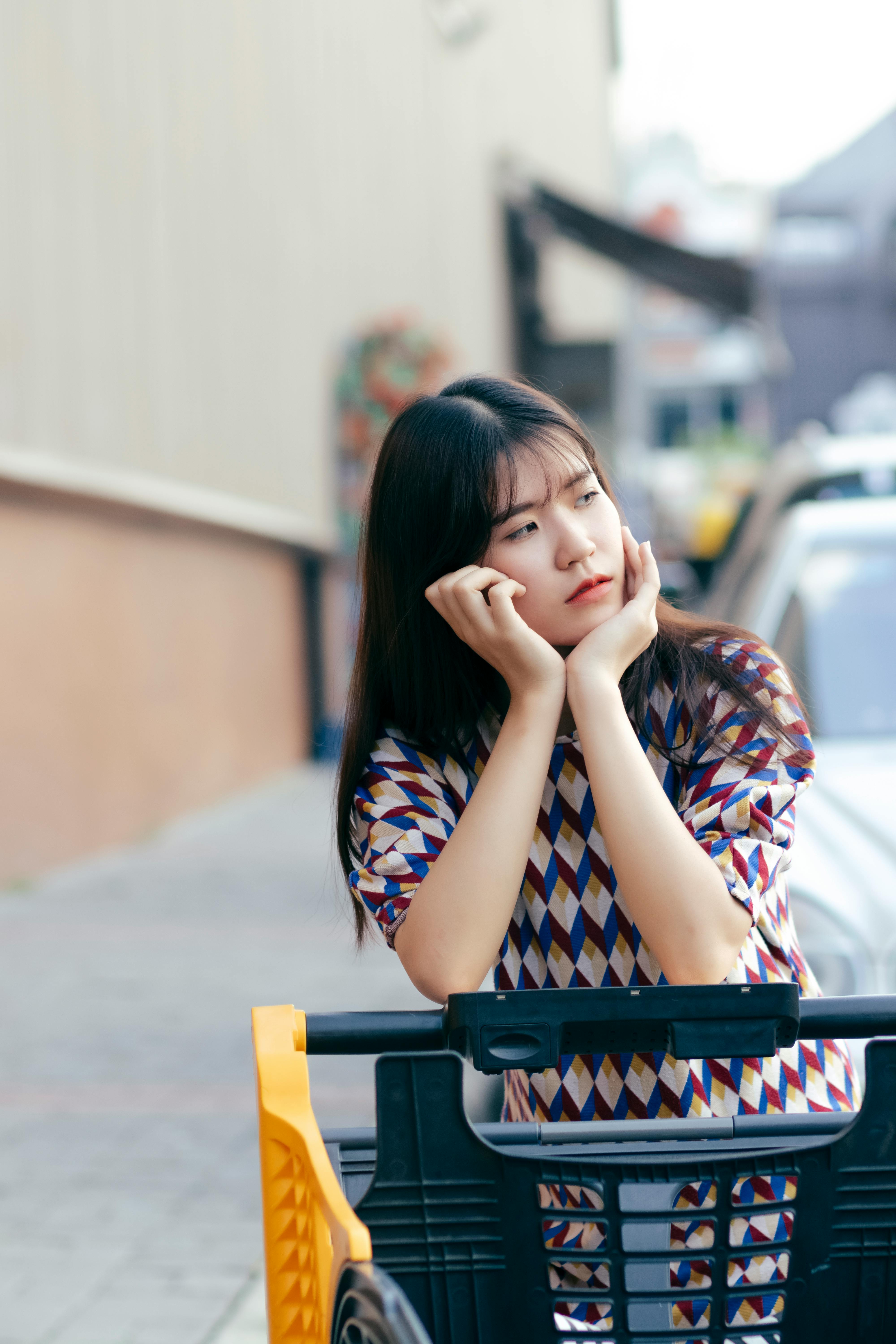 胡志明市一位东亚妇女坐在户外购物车上