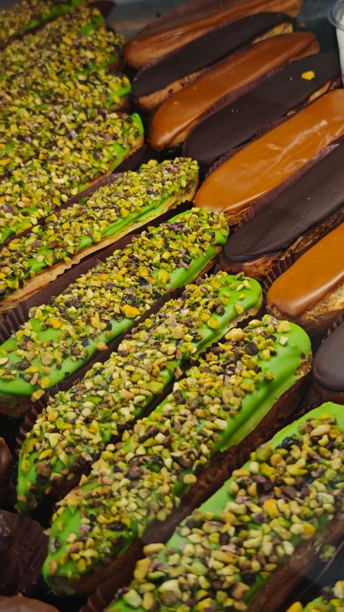 Free Close-up of assorted eclairs topped with pistachios, chocolate, and caramel. Stock Photo