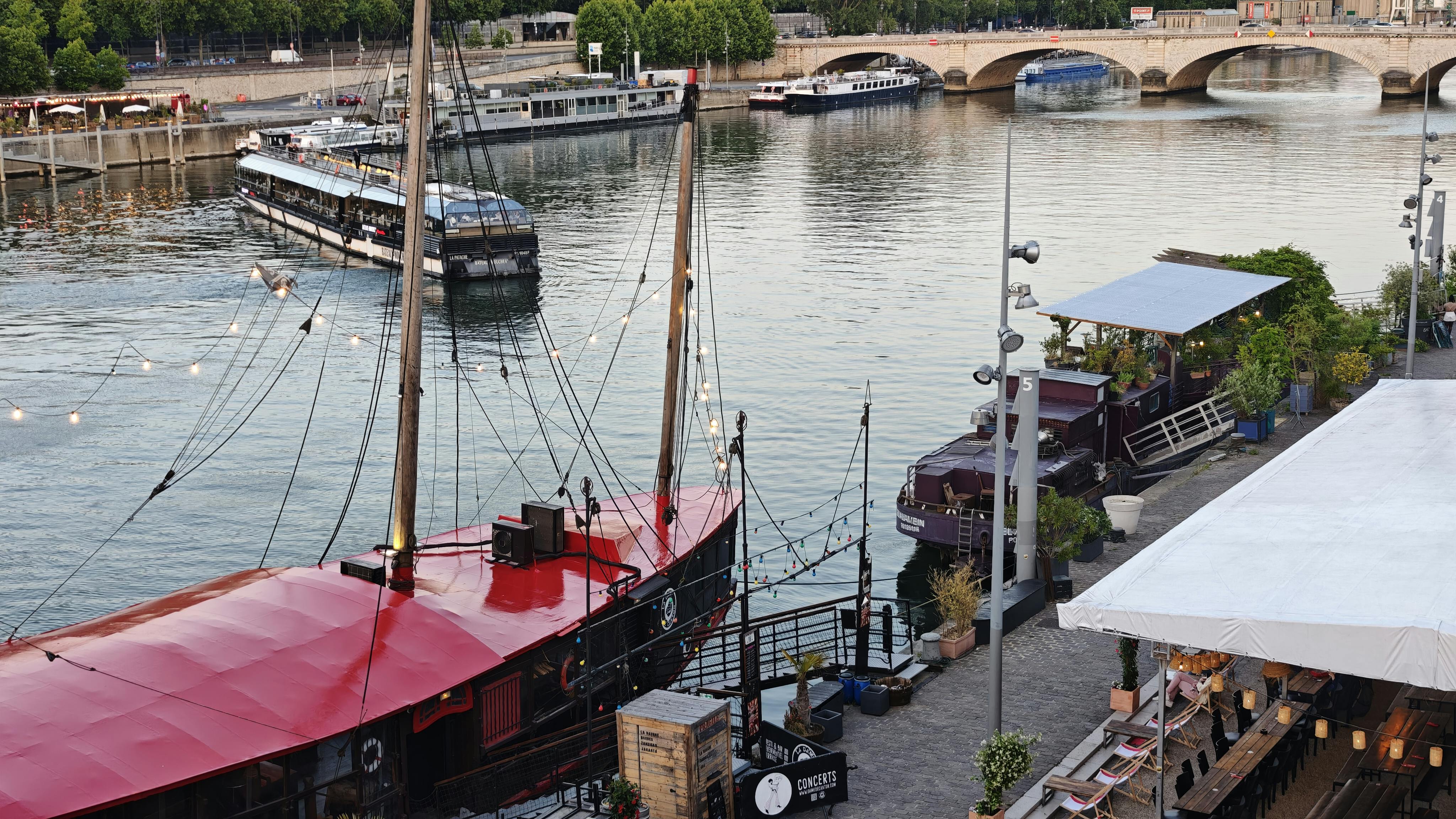 Picturesque scene of boats on the Seine River with a historic bridge in Paris.
