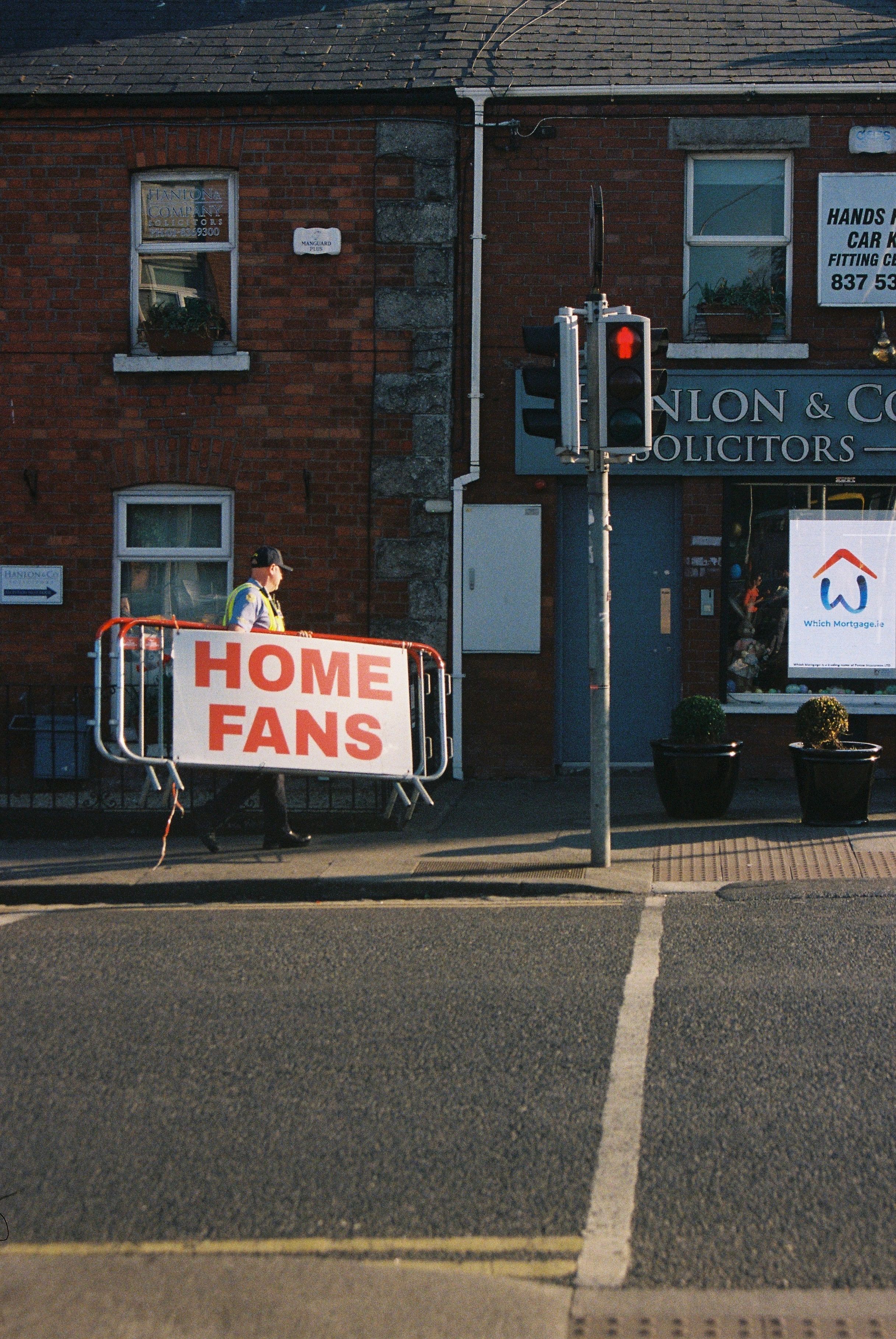 Person Holding Home Fans Sign on City Street · Free Stock Photo