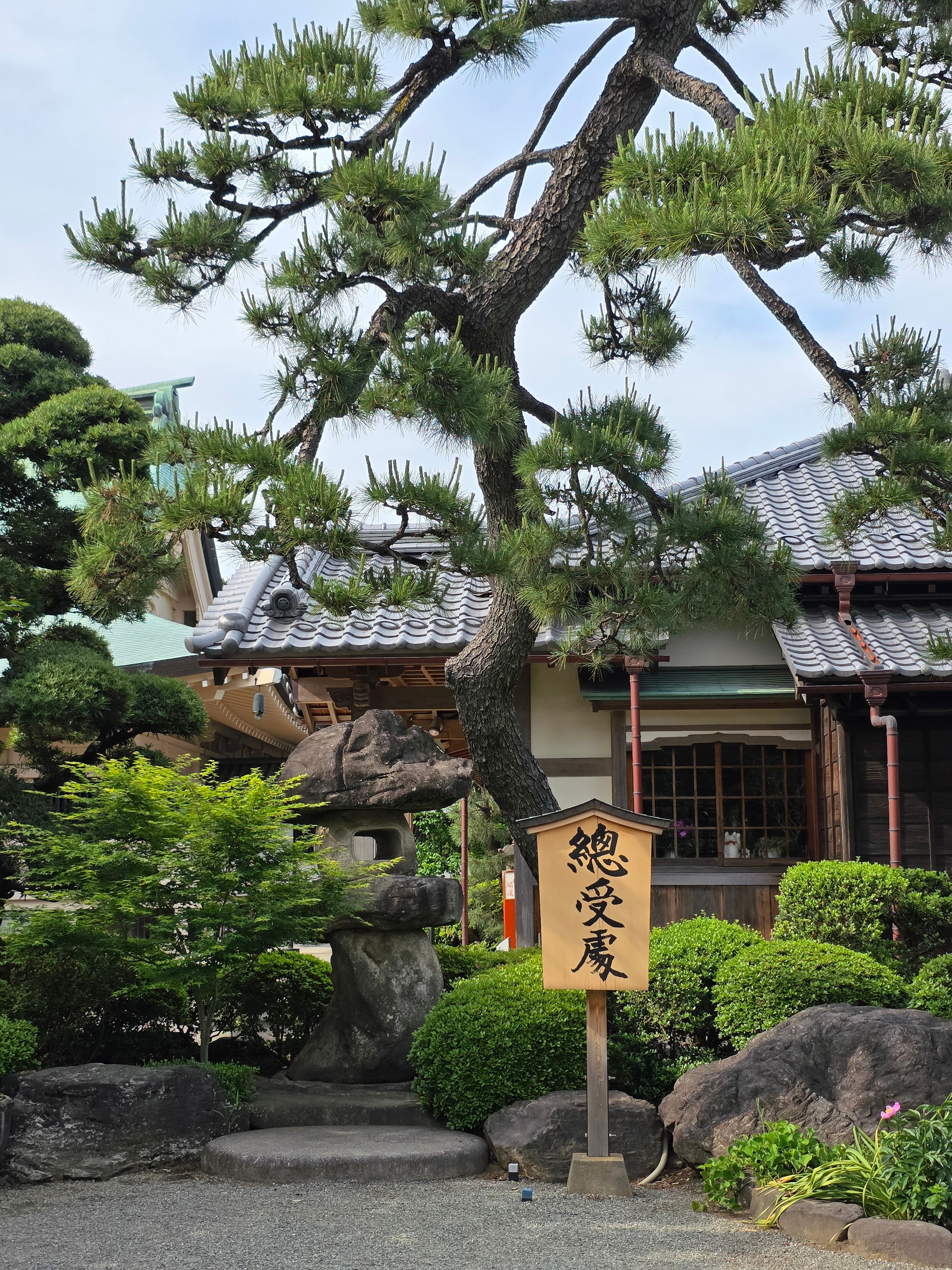 Scenic view of a traditional Japanese garden with wooden architecture and lush greenery.
