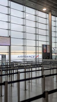 View of an Air France plane from an empty airport terminal with check-in counters.