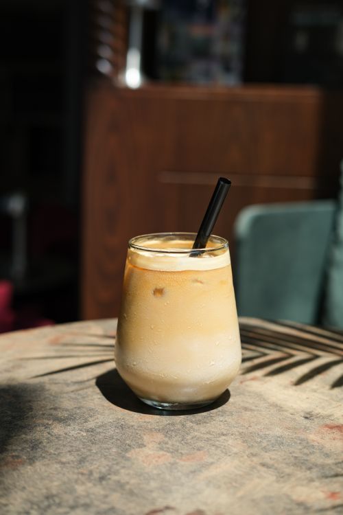 Free Cool iced coffee with black straw, catching sunlight in an Istanbul café. Stock Photo