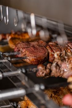 Close-up of juicy grilled meat skewered on a rotisserie, highlighting the perfect grill marks and savory texture.