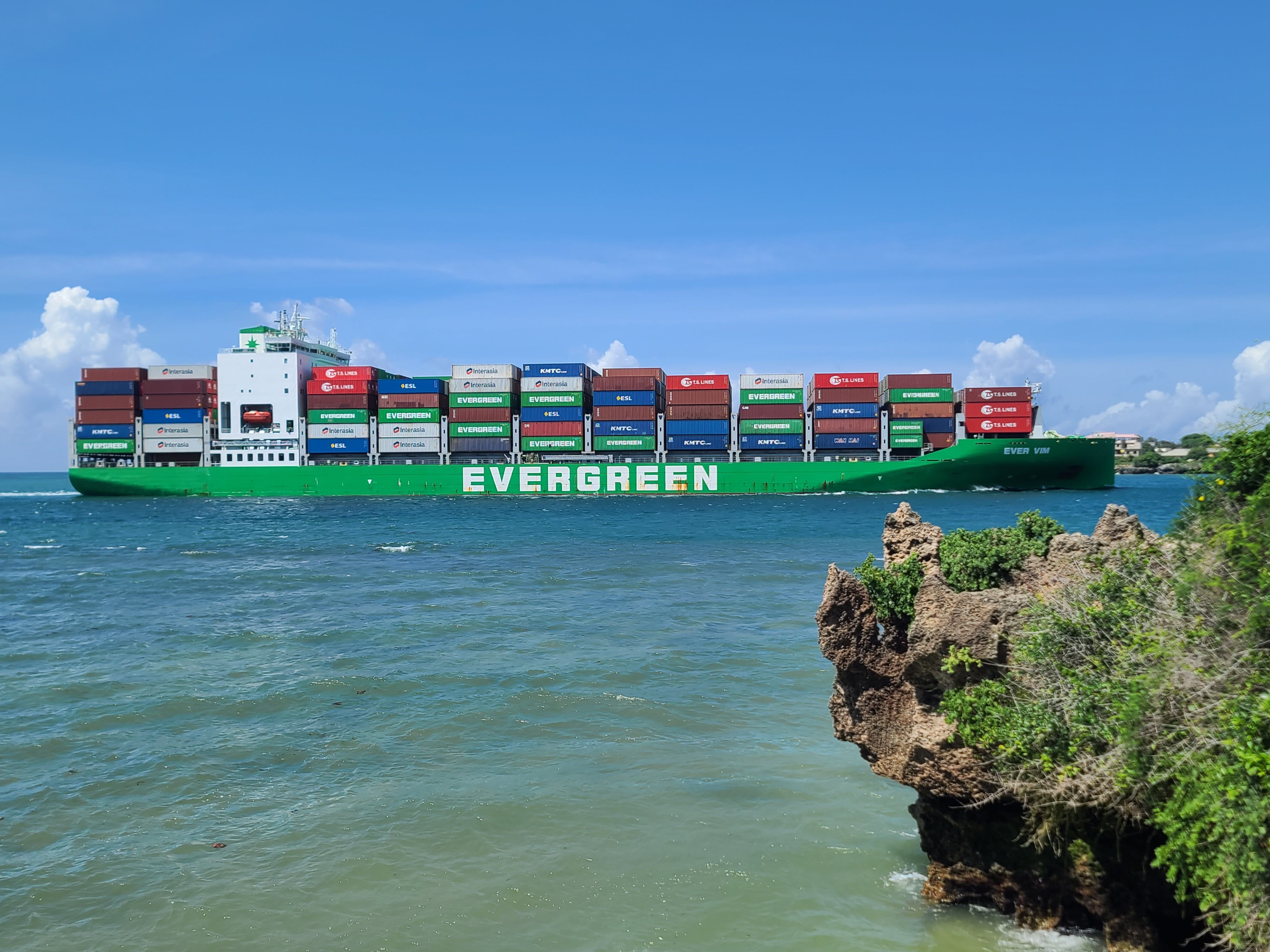 Large Evergreen container ship navigating Mombasa's coastal waters on a sunny day.