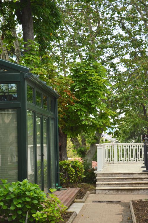 Free Tranquil garden setting featuring a glass pavilion and lush greenery, ideal for relaxation and nature appreciation. Stock Photo