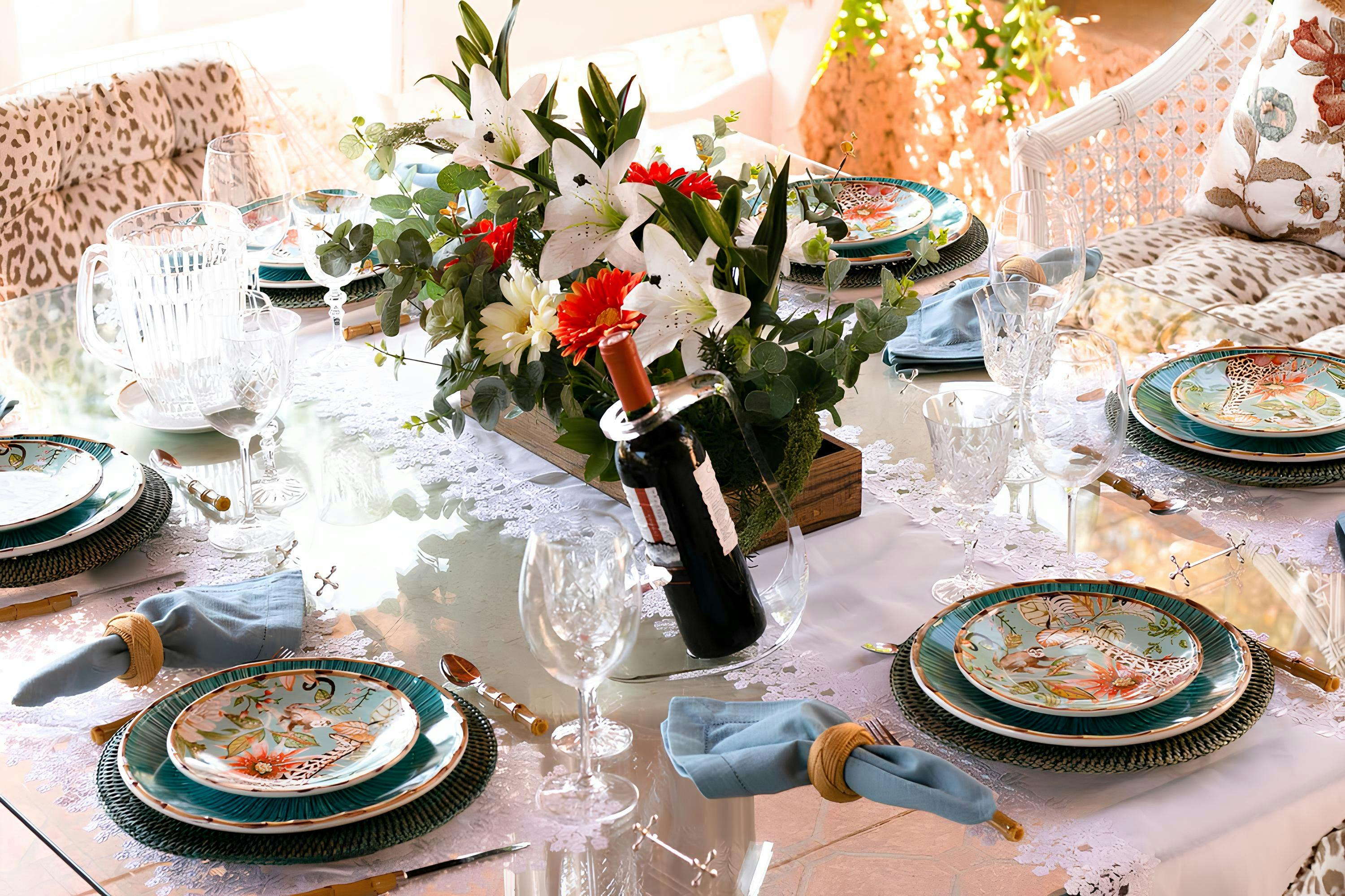 Mesa de celebração decorada com flores e taças, sugerindo um evento social ou reunião familiar ao ar livre.