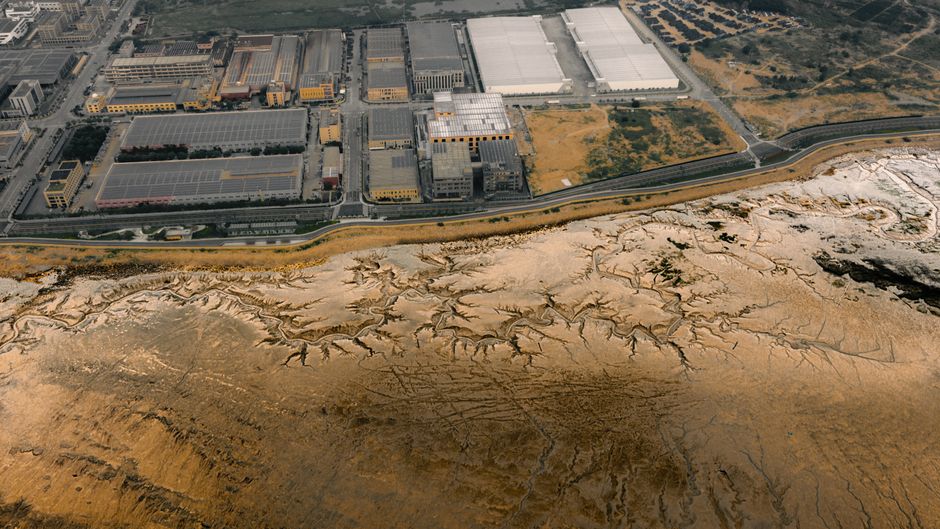 Aerial photo depicting industrial buildings adjacent to salt flats.
