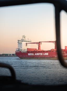 Royal Arctic Line cargo ship sailing in Hamburg harbor during sunset.