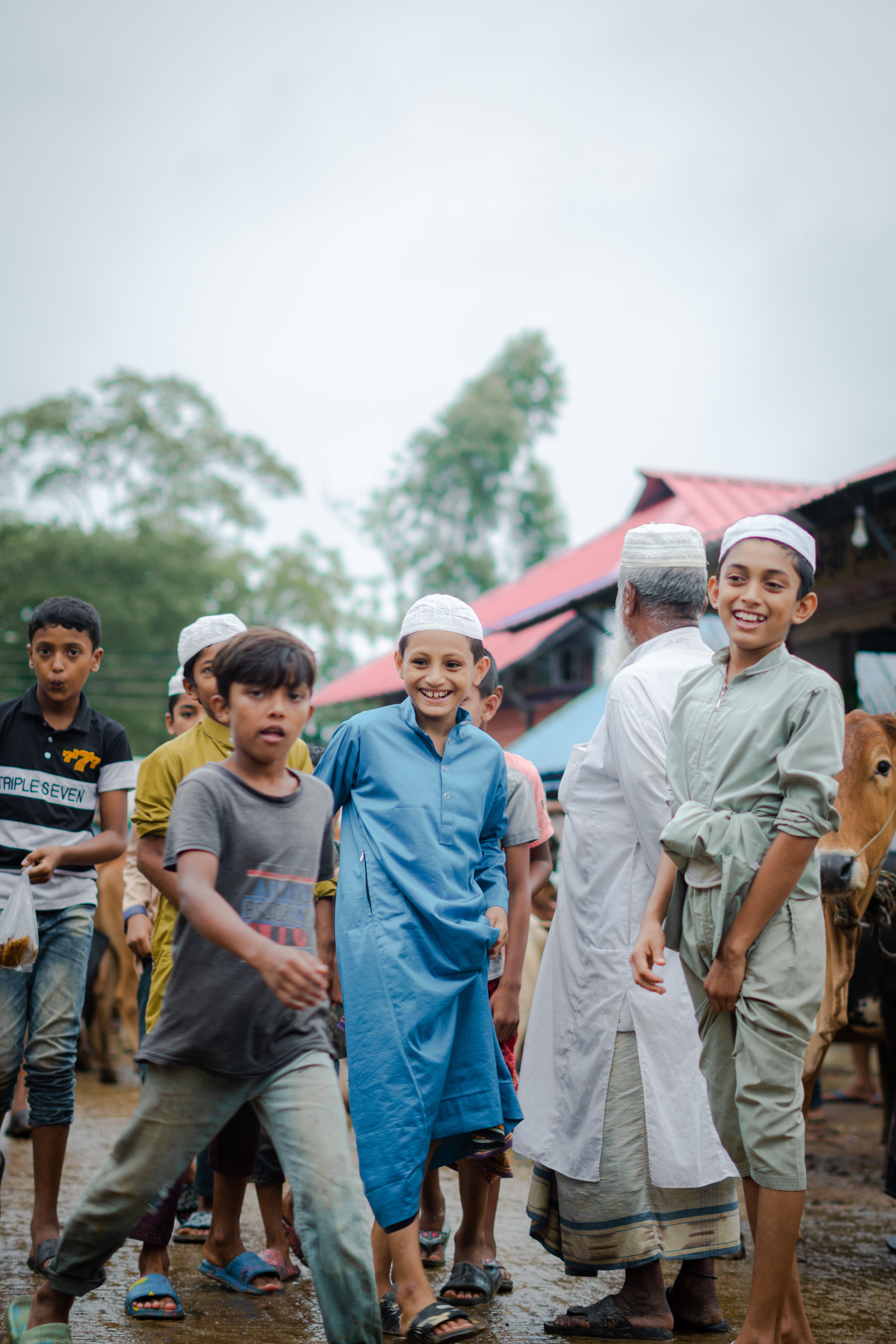 A lively group of children enjoying time outdoors in traditional attire.
