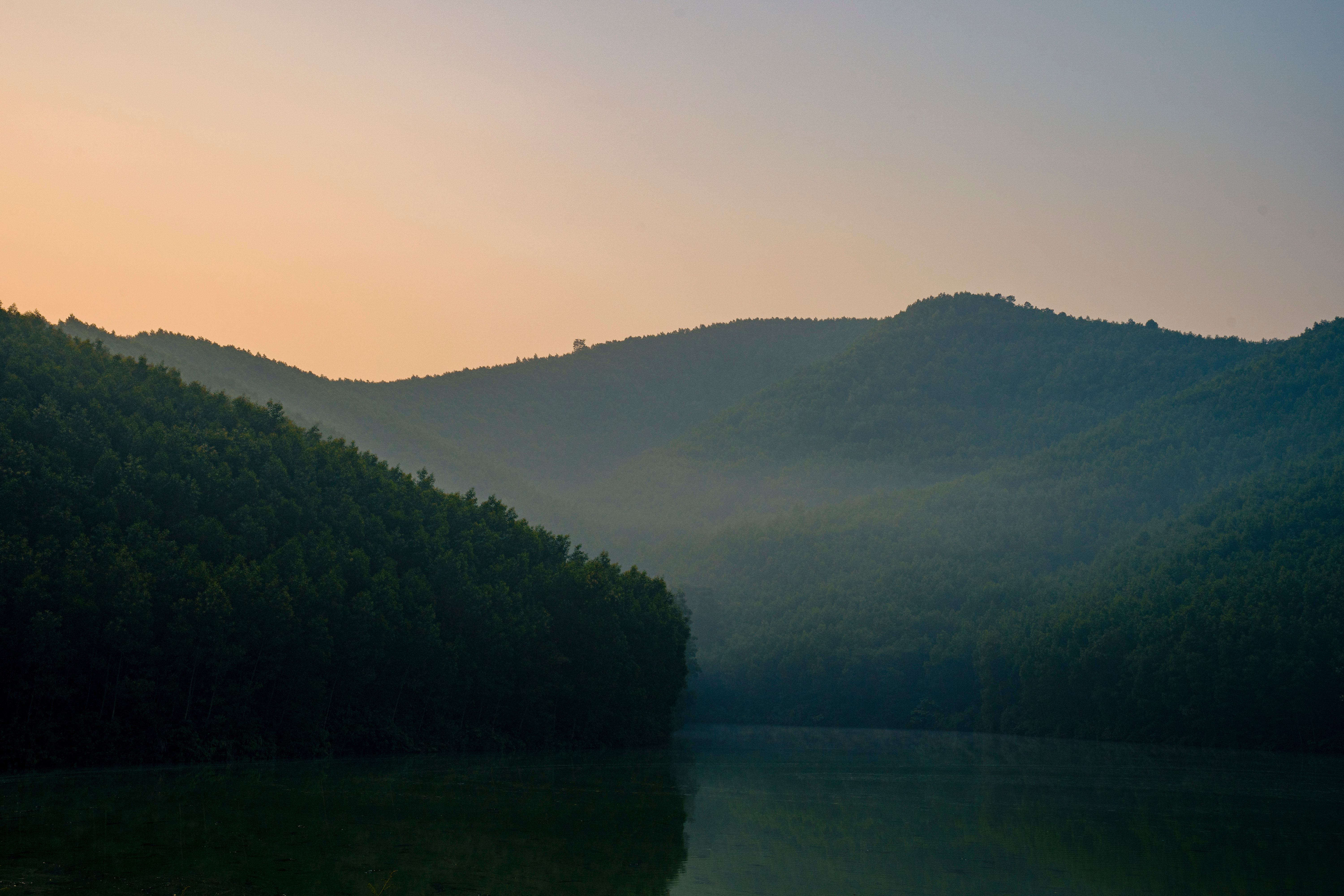 Peaceful misty hills and forested landscape at dawn in Vietnam, showcasing natural beauty.