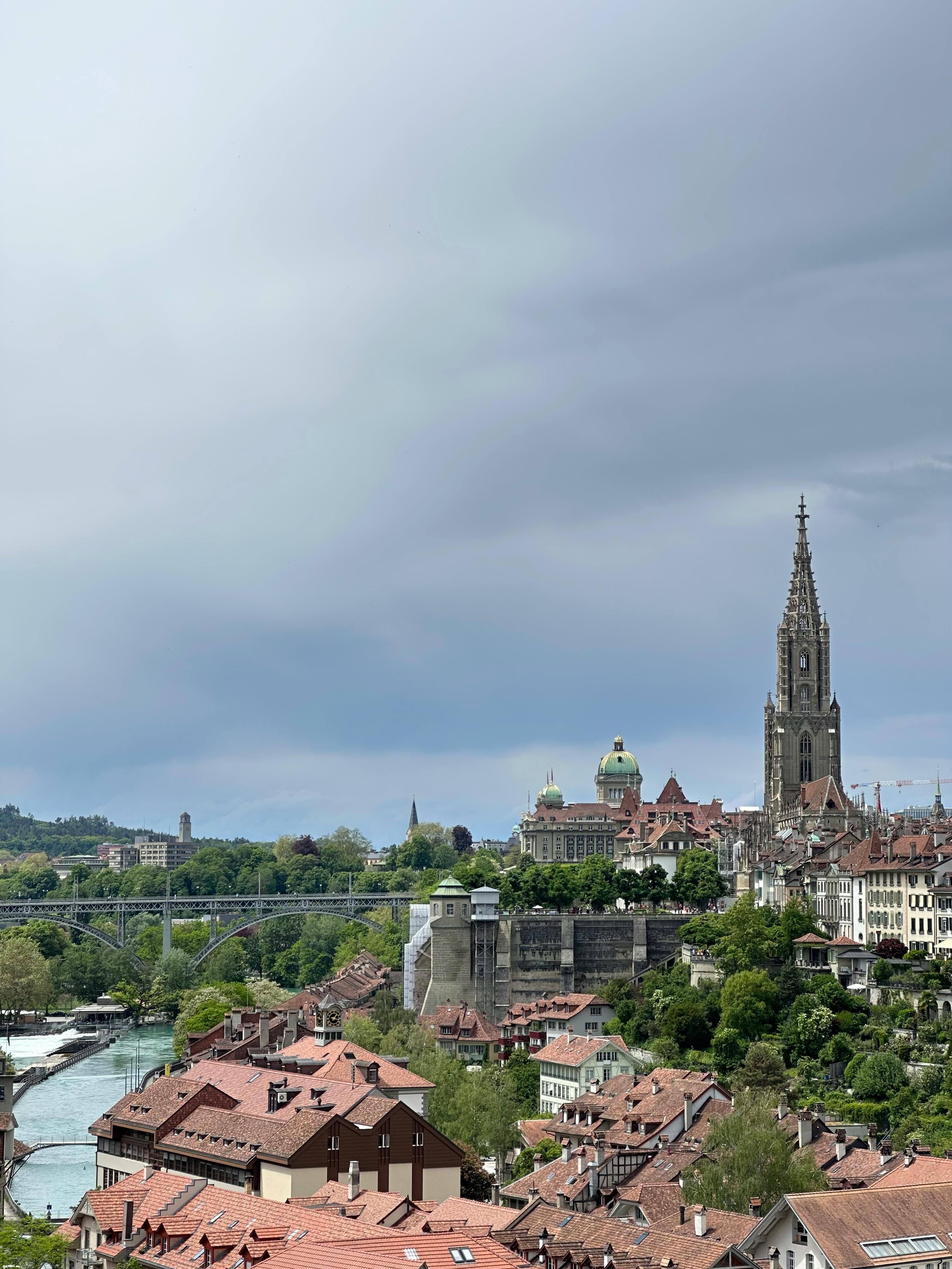 A breathtaking view of Bern featuring the historic Munster Cathedral and scenic river on an overcast day.
