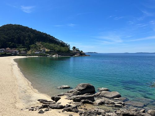 Free Explore a tranquil beach with clear blue waters and rocky coast in Galicia, Spain, ideal for a summer getaway. Stock Photo