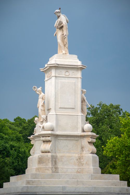 Free Marble statue with classical figures under a dramatic sky in Washington D.C. park setting. Stock Photo