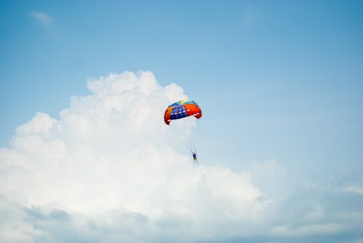 A person enjoying a vibrant parasailing experience high above the clouds on a sunny day.
