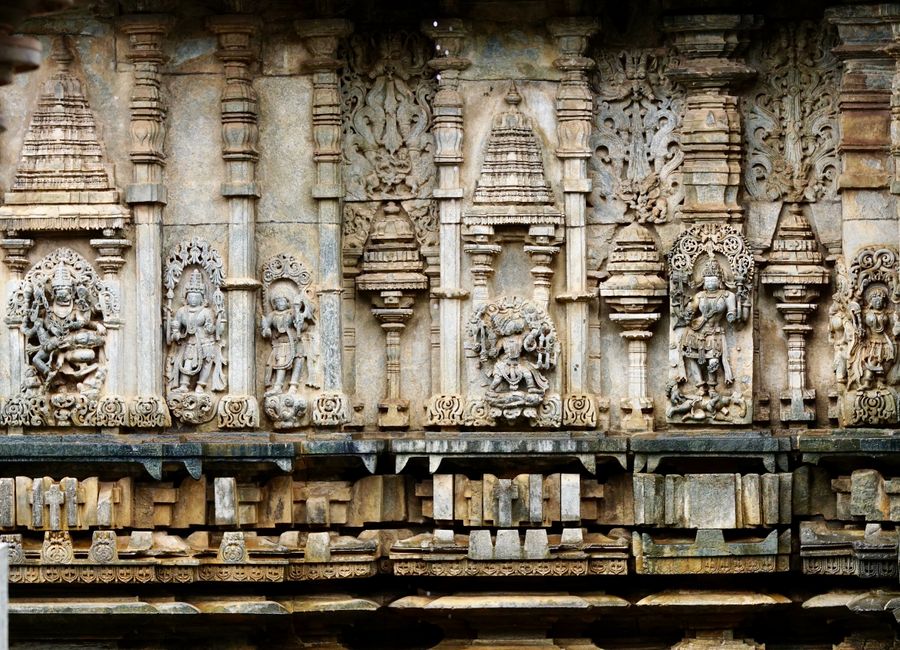 Detailed view of ancient stone carvings at a temple in Karnataka, India.