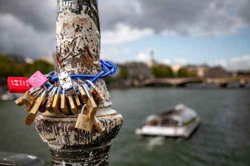 Free Romantic love locks on bridge in Paris with scenic view of Seine River. Stock Photo