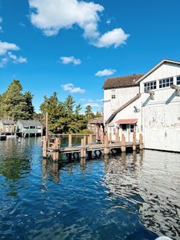 Tranquil scene of a rustic boathouse by the water on a sunny day.
