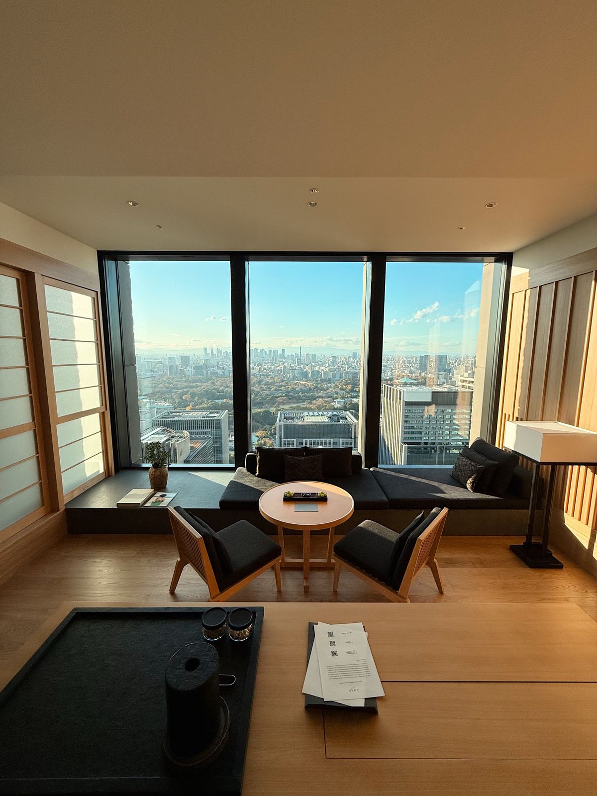 Penthouse living room with floor-to-ceiling windows and city skyline view after a luxury makeover