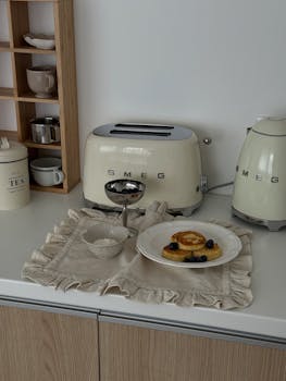 Charming kitchen scene with toaster, pancakes, and tea setup.
