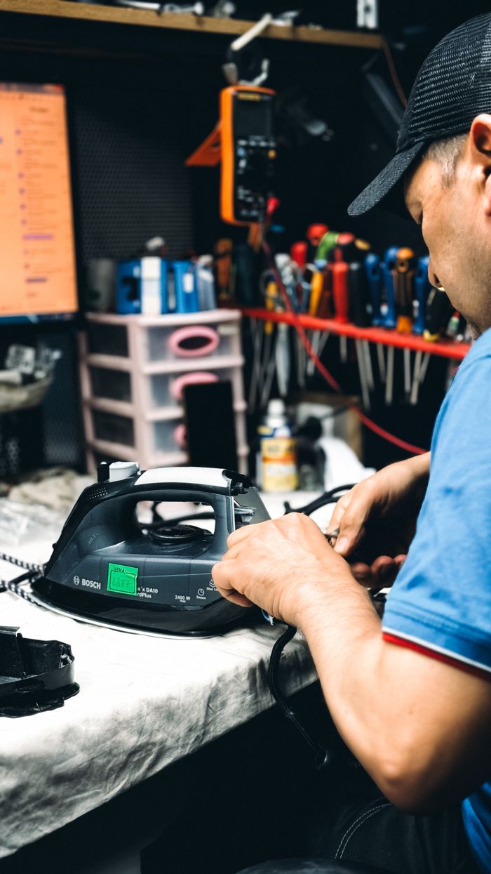 Repairman fixing an electric iron in a workshop