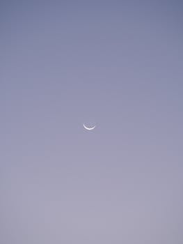 A serene crescent moon set against a soft twilight sky, embodying peace and calm.