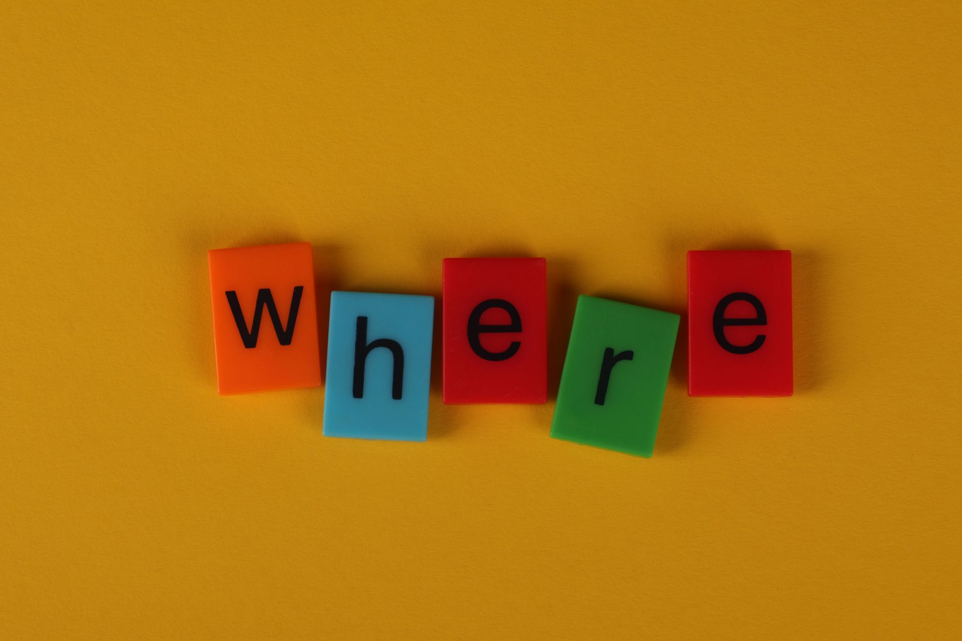 Colorful letter blocks arranged on yellow background spelling 'Where'.