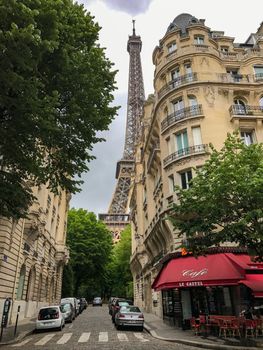 Charming Paris street view with the Eiffel Tower in the background, showcasing classic architecture and vibrant city life.
