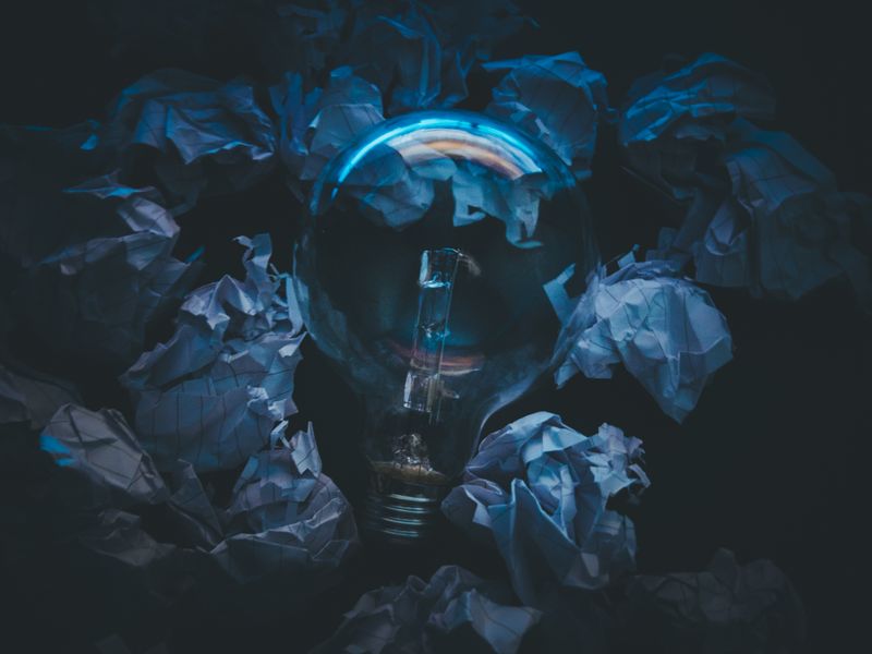 Light bulb surrounded by crumpled paper symbolizes creative ideas and innovation