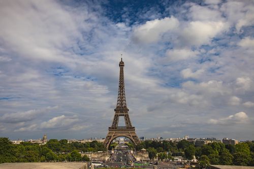Free Majestic view of the Eiffel Tower in Paris under a dramatic cloudy sky. Stock Photo