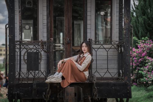 Free Stylish woman sitting on an old train car, blending vintage and modern vibes. Stock Photo