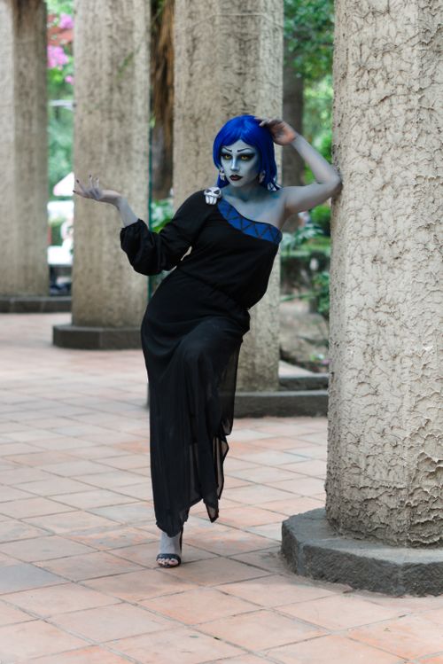 Free Striking cosplay character poses in an artistic outdoor colonnade with bold makeup. Stock Photo