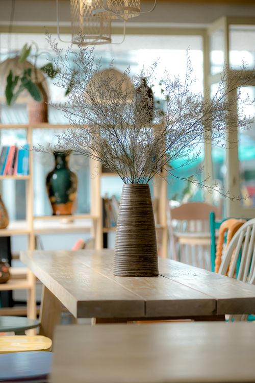 Free Cozy indoor setup with a rustic wooden table and decorative vase. Stock Photo