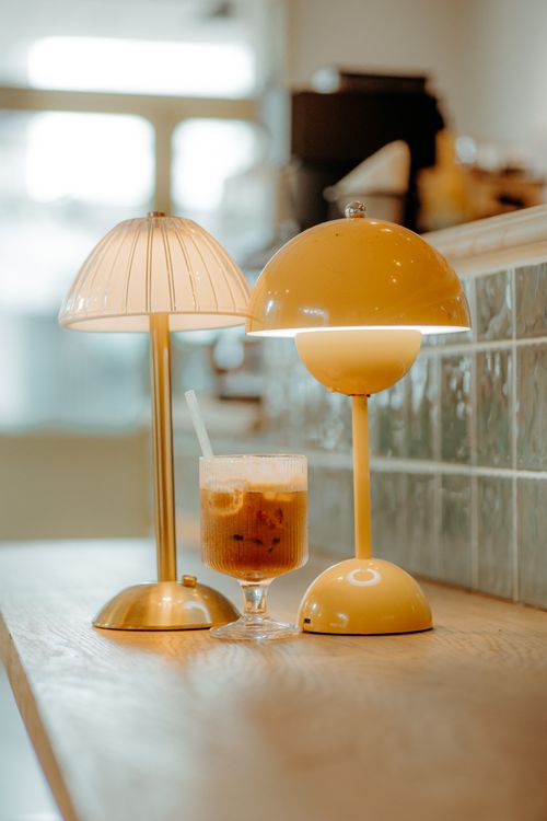 Free Cozy coffee shop interior featuring stylish modern lamps and a refreshing iced coffee. Stock Photo
