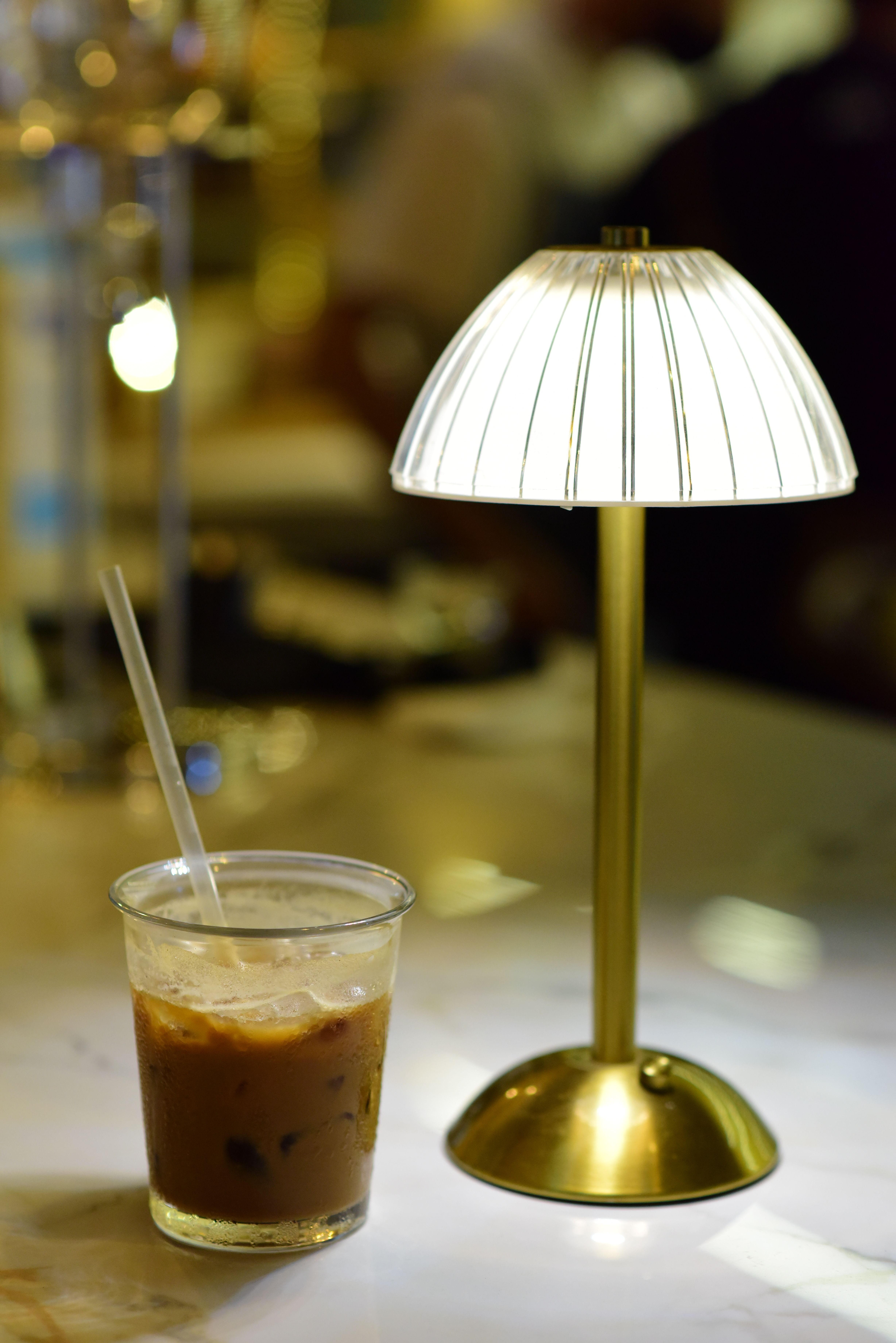 Vintage brass pharmacy lamp placed on a marble countertop next to an espresso machine