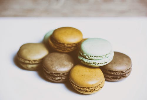 Delicious set of various macarons placed on white table close to each other