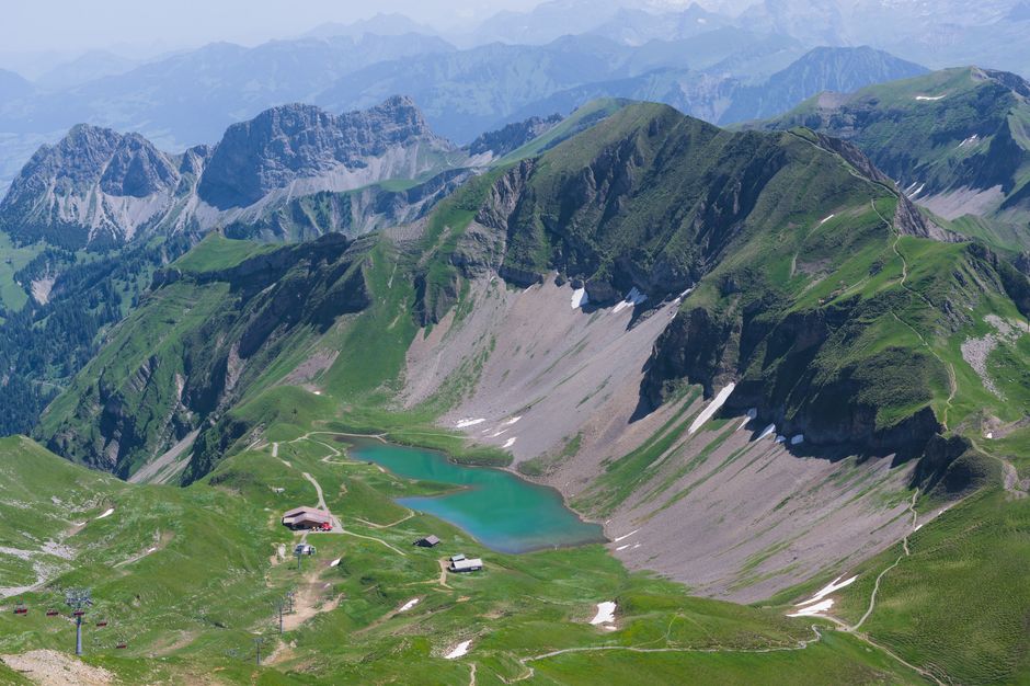 A breathtaking aerial view of a lush Swiss mountain landscape with a serene turquoise lake.