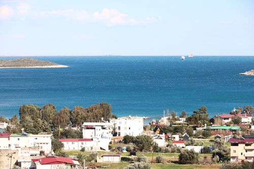 Free Picturesque coastal image featuring a village and sea under a vivid sky. Stock Photo