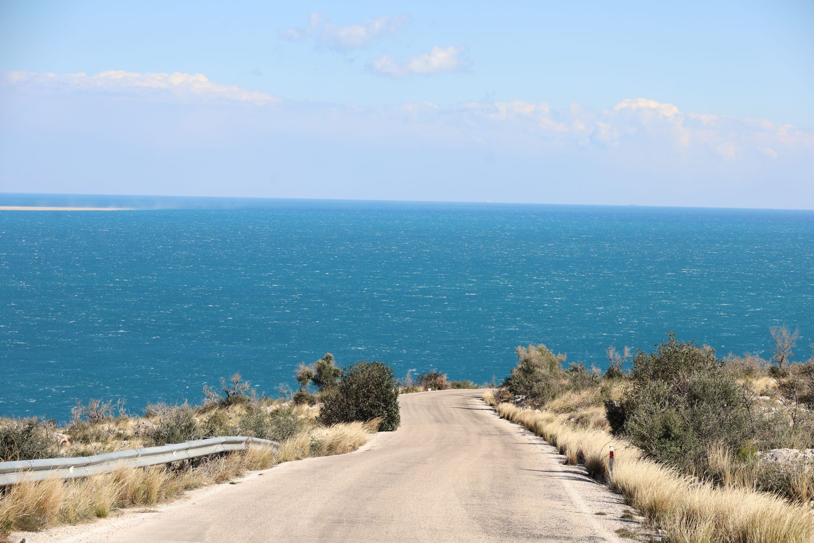 Representative coastal road leading toward the sea