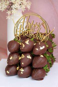 Delicious chocolate-covered strawberries with gold accents in a birthday themed display.