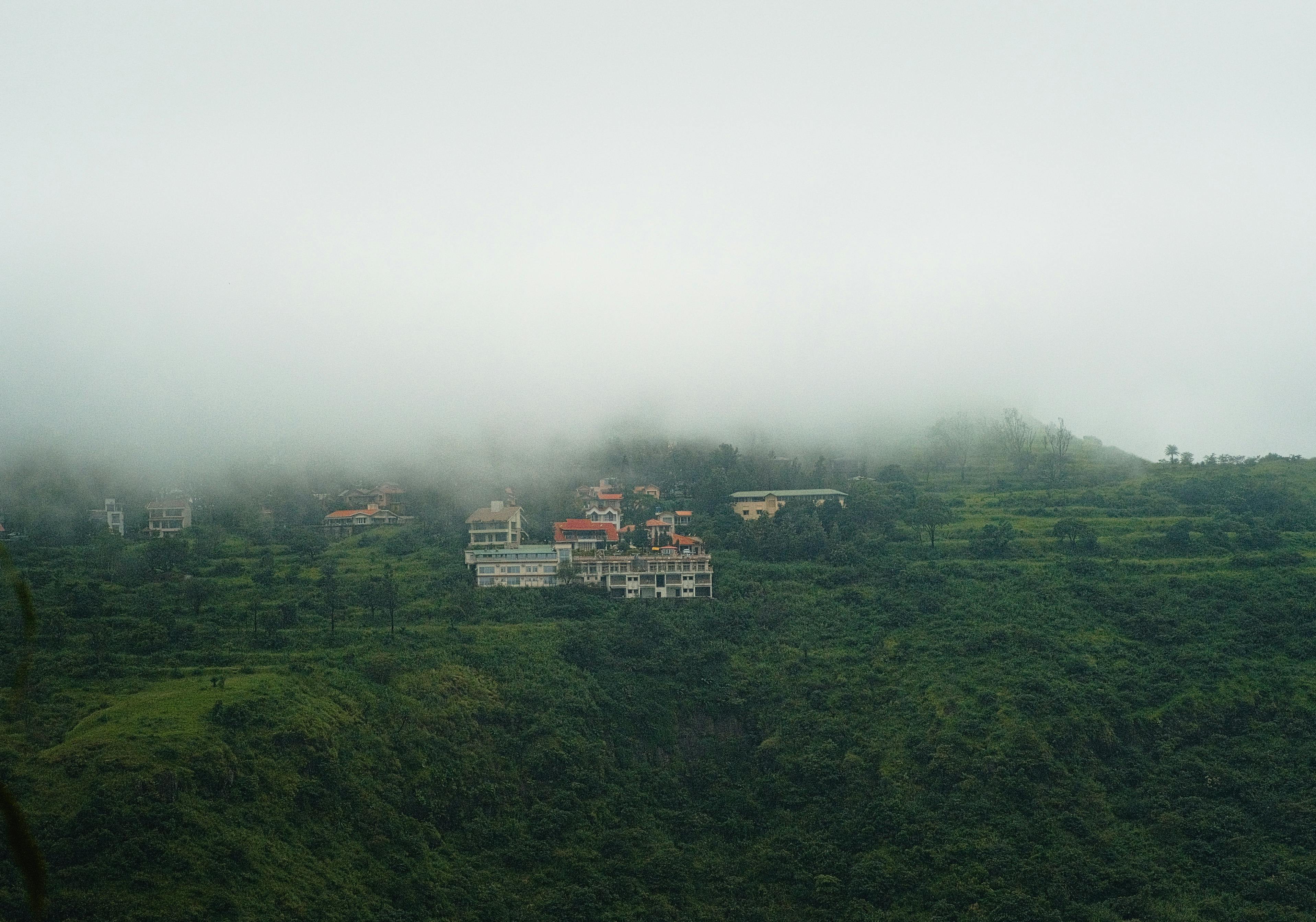 A picturesque view of lush green hills and misty clouds in Mahabaleshwar, India.