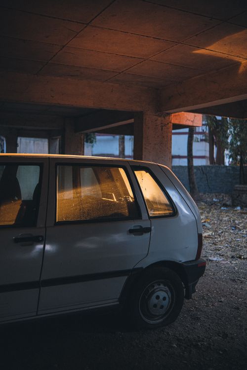 Free A vintage car parked in a dimly lit, abandoned garage, evoking a sense of retro nostalgia. Stock Photo