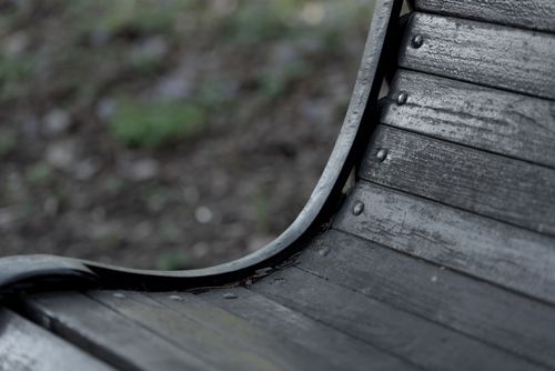 Free Close-up of a weathered wooden bench in a natural outdoor setting, capturing rustic charm. Stock Photo